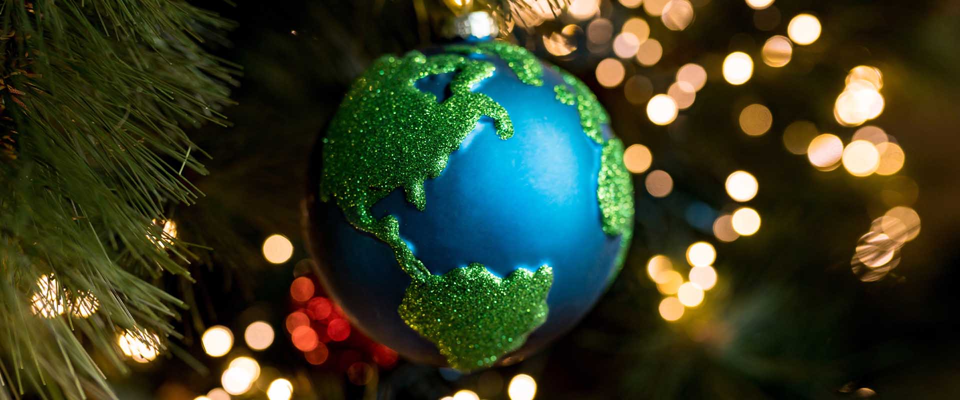 Pallina di Natale con il mondo sull’albero, simbolo delle tradizioni natalizie nel mondo